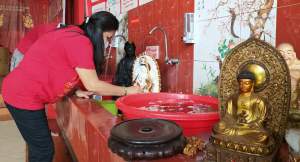  Seorang jamaah Vihara Kwan In Thang Pamulang saat lakukan pencucian rupang jelang Imlek 12 Februari pekan depan.
