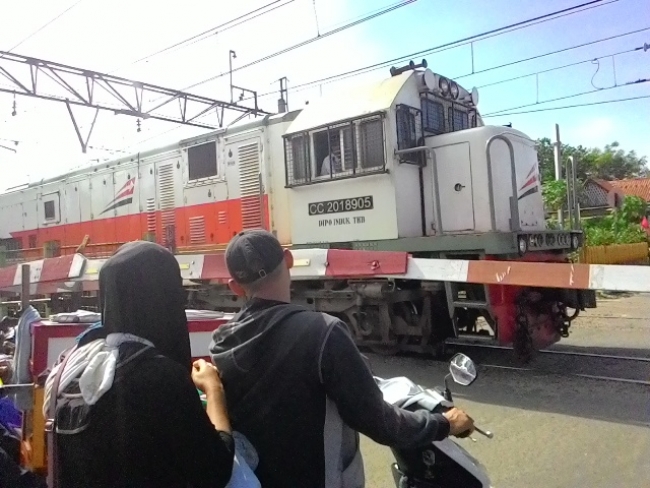 Pintu perlintasan kereta api di stasiun Sudimara Jombang
