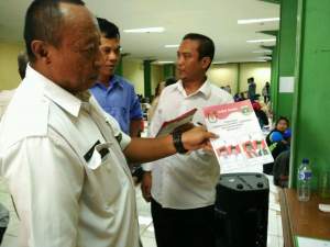Petugas KPU Kabupaten Tangerang menunjukkan surat suara yang buram.