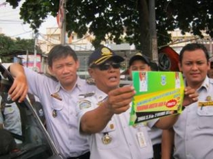 Pamulang- Tampak Kabid angkutan, Wijaya Kusuma,menunjukan stiker tanda angko gratis, Senin (25/11)DT