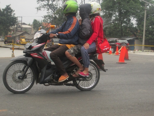 pengendara roda dua saat melintas di ruas jalan yang mulai terlihat mulus di perempatan Muncul, Kecamatan Setu.