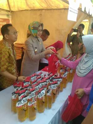 Walikota Airin Rachmi Diany bersama Direktur APP Suhendra Wiriadinata melayani warga yang membeli minyak goreng murah.