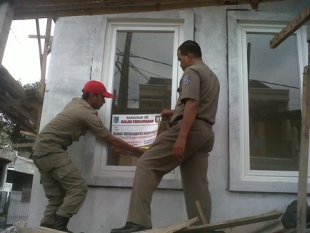 Pkd Aren- Petugas Satpol PP saat memasang stiker Pengawasan pada Rumah mewah 3 lantai (dt)