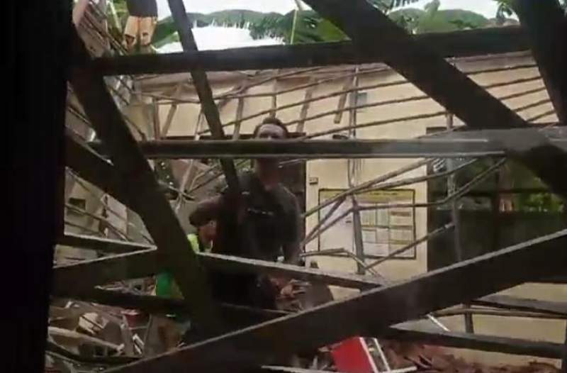 Seorang pekerja tengah membongkar kerangka atap SDN 02 Pondok Cabe Udik yang roboh akibat angin kencang.