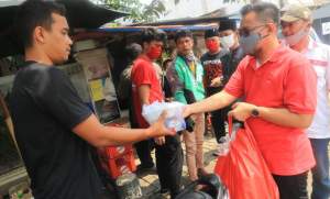 Kader PDI Perjuangan Kecamatan Serpong bagikan nasi bungkus kepada ojek pangkalan di kawasan Serpong.